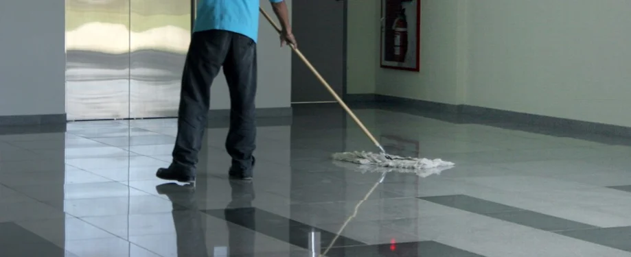 Dust mopping a polished floor in a commercial lobby